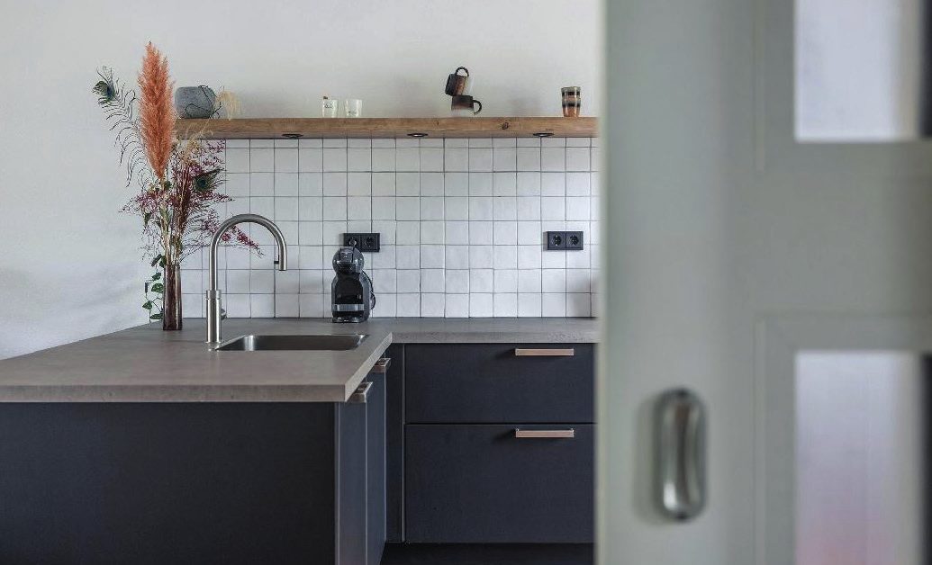 Keuken met zwarte fronten en een houtlook werkblad, gewrapt