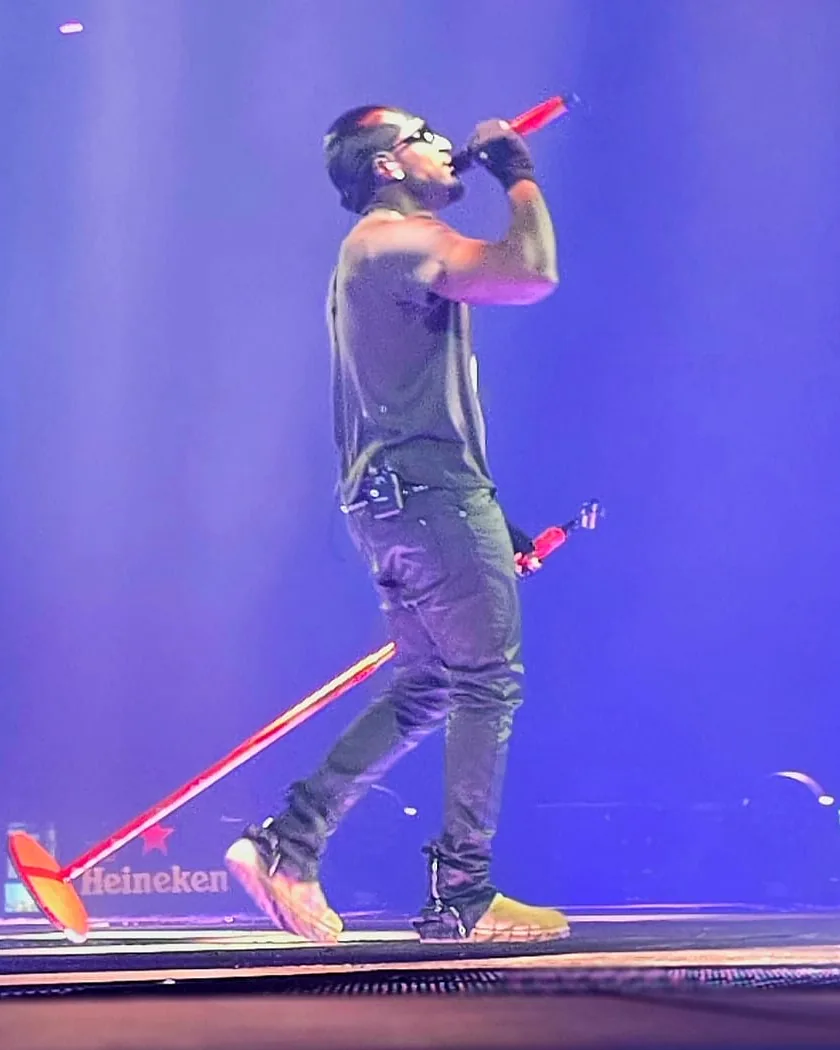 Rapper Frenna zingt op het podium met een rood gewrapte draadloze Shure-microfoon van WRPPN