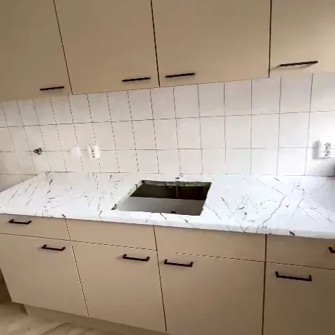 keuken in taupe met werkblad in witte marmerlook, langzaam in beeld