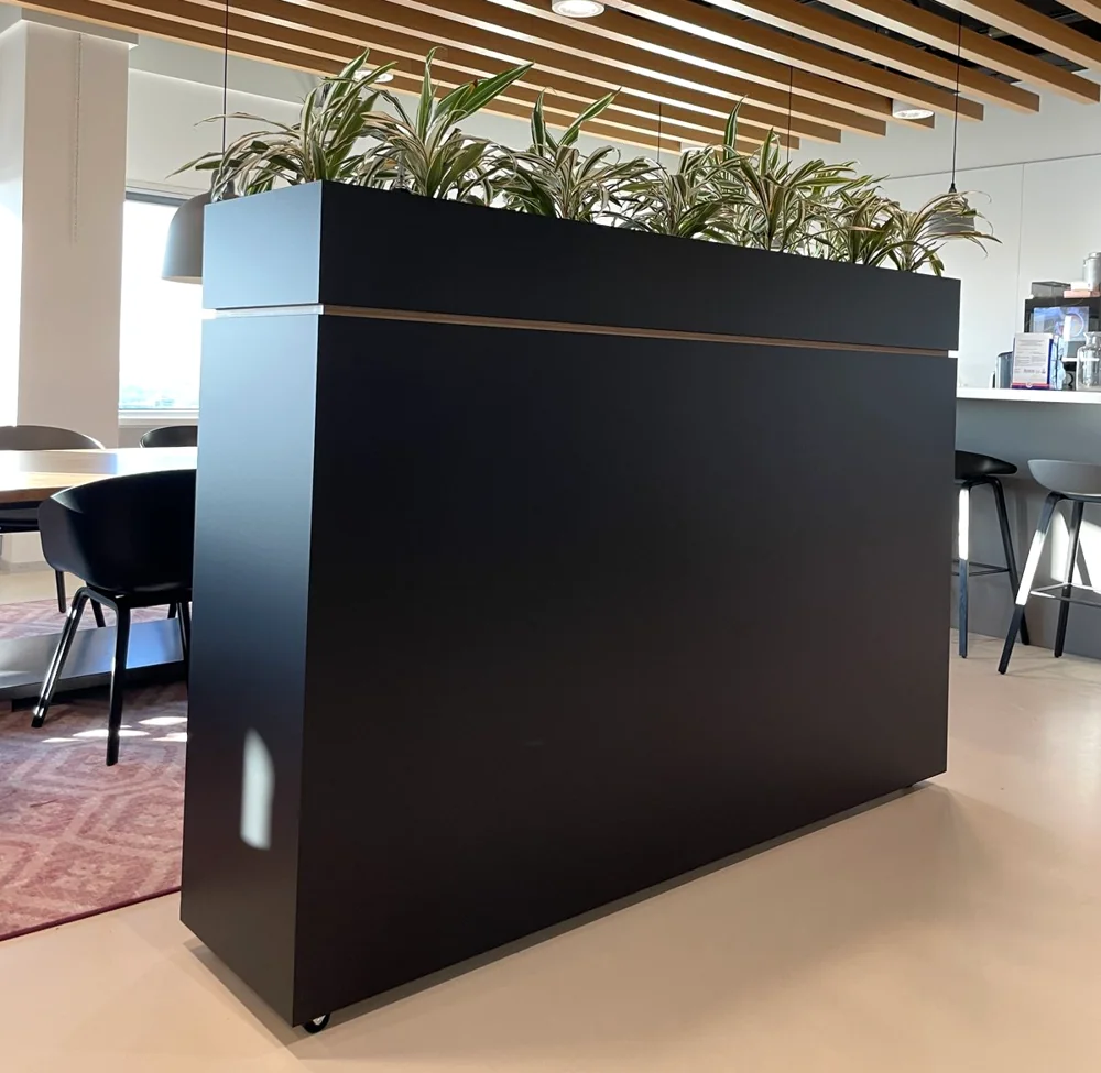 Roomdivider met plantenbak in een open kantoor, gewrapt in mat zwart door WRPPN