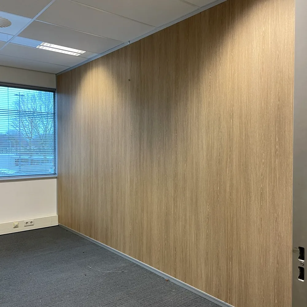 Kantoorwand gewrapt in lichte houtlook, met vloerbedekking en systeemplafond