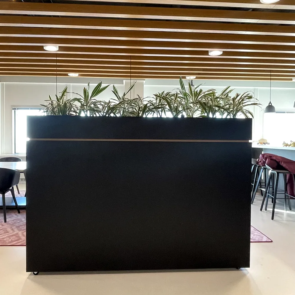 Na: roomdivider met plantenbak gewrapt in mat zwart