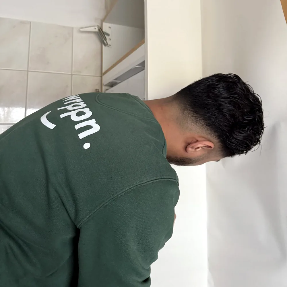 Monteur van WRPPN werkt de folie langs de rand van een wand af