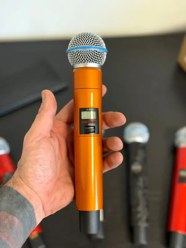 Hand met microfoon in metallic oranje