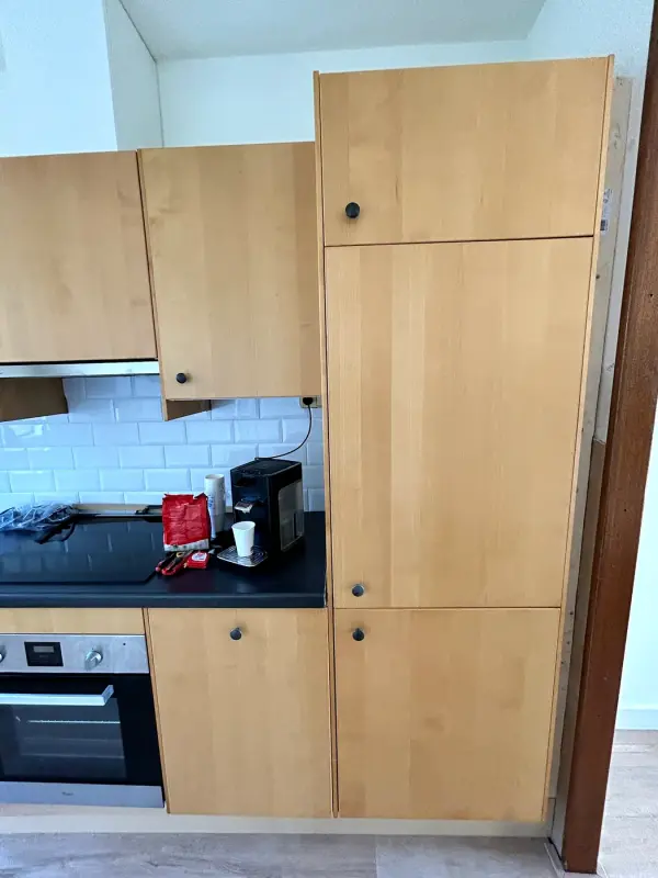 Voor: hoge kast en kookplaat met houten fronten