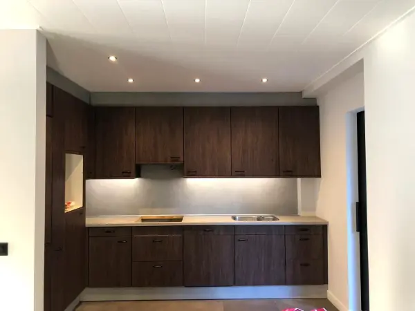 Na: keukenwand in donkere houtnerf