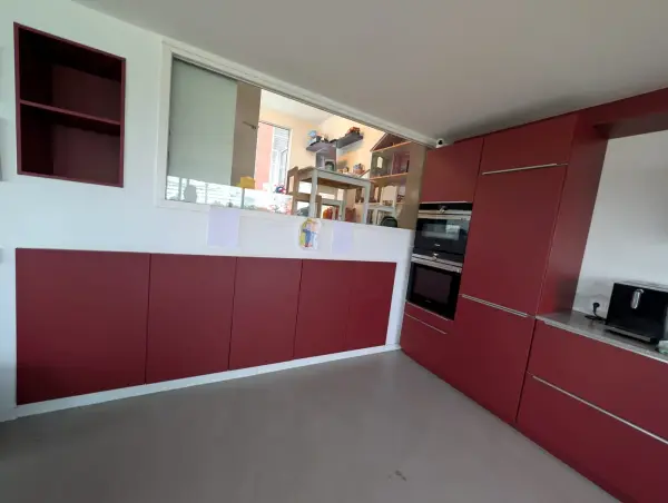 Rode keuken met zicht op de woonkamer