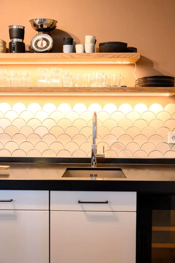 Spoelbak onder open planken met verlichting