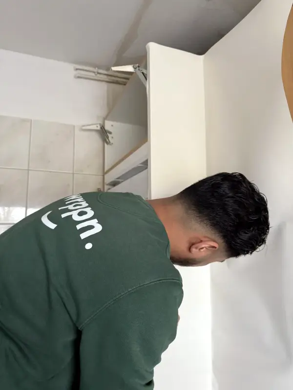 Monteur van WRPPN werkt de folie langs de wand af