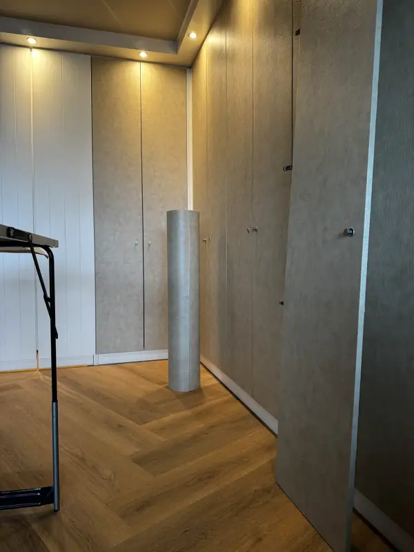 Ruimte met een kastenwand in beige leather look tijdens de oplevering