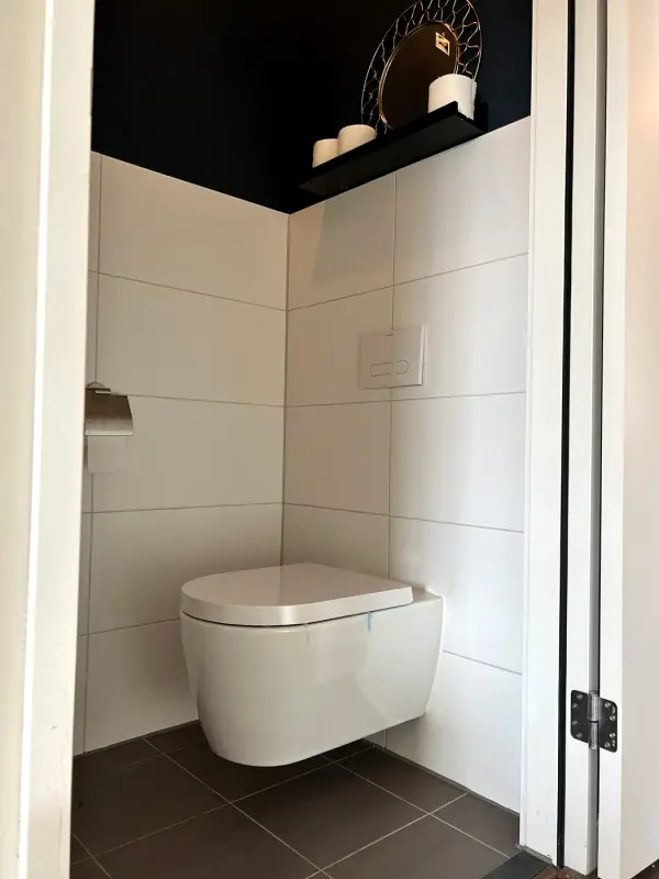 Voor: toiletruimte met witte tegels