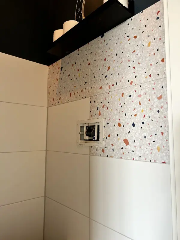Tijdens: terrazzofolie half aangebracht rond de bedieningsplaat
