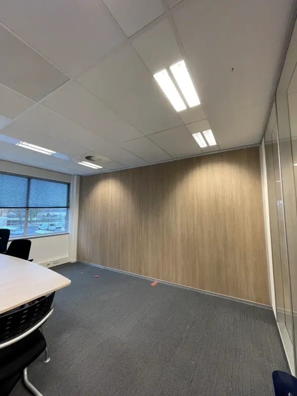 Kantoorruimte met een lange wand in houtlook en ramen links