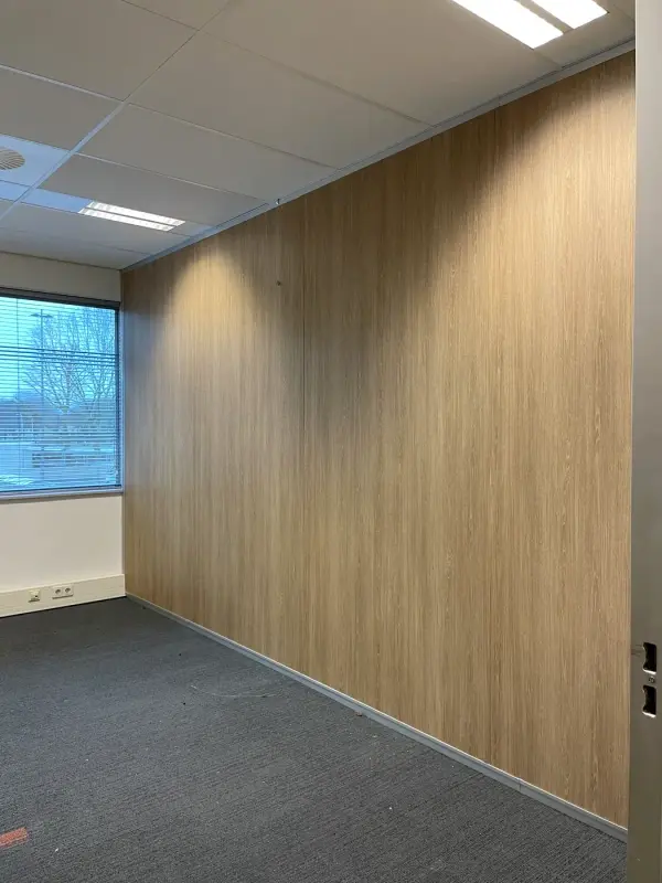 Gang met een wand in donkere steenlook en een lichte houten vloer