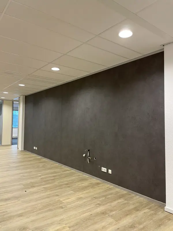 Kantoorwand in donkere steenlook boven een lichte houten vloer